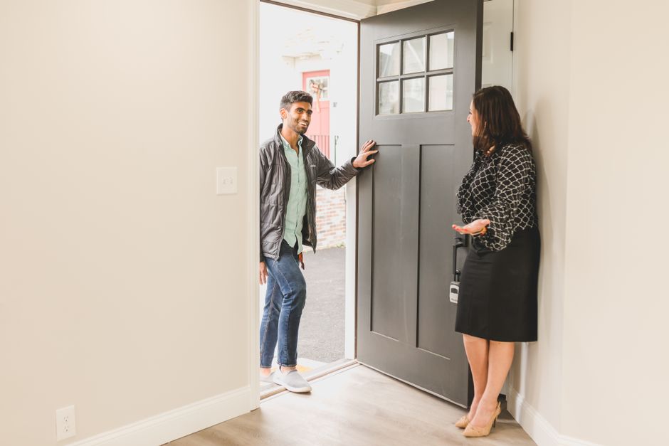 Real estate agent greeting a business client warmly at the entrance of a commercial property